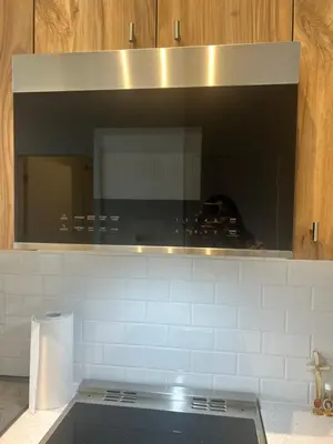 a kitchen with a microwave above a stove at Luxury Condo with Hottub, outdoor firepit & Bowlin in Kitchener