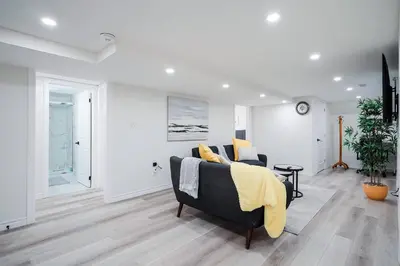 a living room with a couch with a yellow blanket at Stylish, Spacious 6-Bedroom Home in the GTA in Whitby