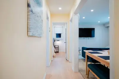 a hallway leading to a living room with a dining room table at Stylish, Spacious 6-Bedroom Home in the GTA in Whitby