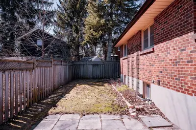 a yard next to a fence next to a house at Stylish, Spacious 6-Bedroom Home in the GTA in Whitby