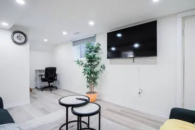a living room with two stools and a flat screen tv at Bright & Cozy Home in the GTA (Basement Apartment) in Whitby