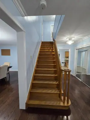 a staircase in a living room with a stair case at Peaceful Country Home on 25 Acres of Wooded Land in Alliston