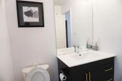 a bathroom with a sink and a toilet and a mirror at Entire 3 bedroom townhouse in Cambridge