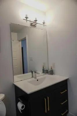 a bathroom with a sink and a large mirror at Entire 3 bedroom townhouse in Cambridge