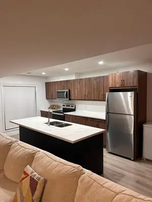 a kitchen with a stainless steel refrigerator and a couch at Entire 3 bedroom townhouse in Cambridge
