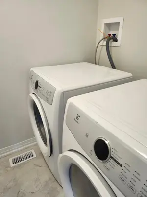 a washing machine and a dryer in a room at Sunrise Villa in Fort Erie