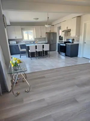 a kitchen with blue cabinets and a table with flowers on it at Sunrise Villa in Fort Erie