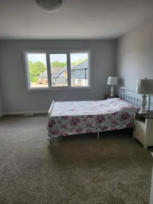 a bedroom with a bed and a window at Sunrise Villa in Fort Erie