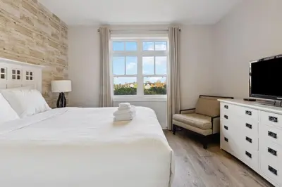 a white bedroom with a large bed and a window at Alpine Breeze Getaway at Blue in Blue Mountains