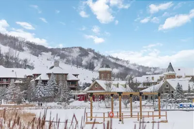 a ski lodge with a snow covered mountain in the background at Alpine Breeze Getaway at Blue in Blue Mountains