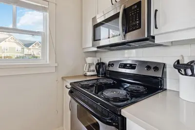 a kitchen with a stove and a microwave at Alpine Breeze Getaway at Blue in Blue Mountains