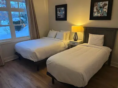 two beds in a room with a window at Alpine Breeze Getaway at Blue in Blue Mountains