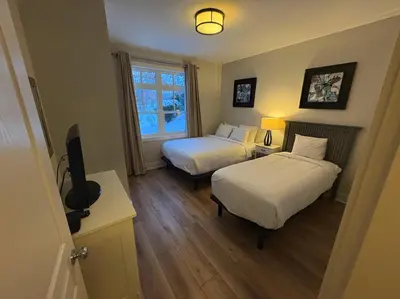 a hotel room with two beds and a television at Alpine Breeze Getaway at Blue in Blue Mountains