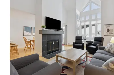 a living room with a fireplace and a tv at Slopeside Ski In Ski Out Second Floor Condo in Blue Mountains