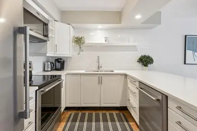 a kitchen with white cabinets and a sink at Slopeside Ski In Ski Out Second Floor Condo in Blue Mountains