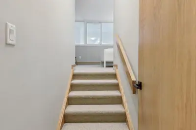 a stairway leading up to a room with a window at Slopeside Ski In Ski Out Second Floor Condo in Blue Mountains