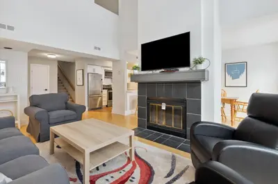 a living room with a fireplace and a tv at Slopeside Ski In Ski Out Second Floor Condo in Blue Mountains