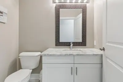 a white bathroom with a toilet and a mirror at Family Townhome in Historic Snowbridge in Blue Mountains