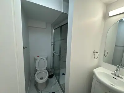 a bathroom with a toilet and a shower and a sink at Basement Suite 2 bedroom s in Oshawa