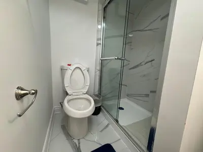 a bathroom with a toilet and a glass shower at Basement Suite 2 bedroom s in Oshawa