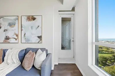 a living room with a blue couch and a window at Modern Lakeside 1BR Condo in Downtown Toronto in Toronto