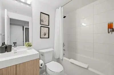 a white bathroom with a toilet and a sink at Modern Studio-Style Condo in Downtown Toronto in Toronto