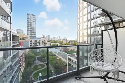 a balcony with a chair and a view of a city at Modern Studio-Style Condo in Downtown Toronto in Toronto