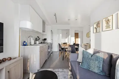 a kitchen and living room with a couch and a table at Bright 2BR Condo w Patio Central Toronto Retreat in Toronto