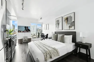a bedroom with a large bed and a large window at Chic DT TO Studio Getaway Perfect for Couples in Toronto