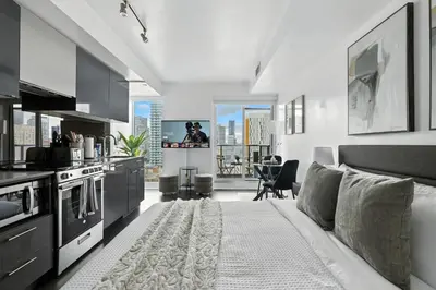 a living room with a couch and a kitchen at Chic DT TO Studio Getaway Perfect for Couples in Toronto
