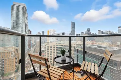 a balcony with a table and chairs and a view of the city at Chic DT TO Studio Getaway Perfect for Couples in Toronto