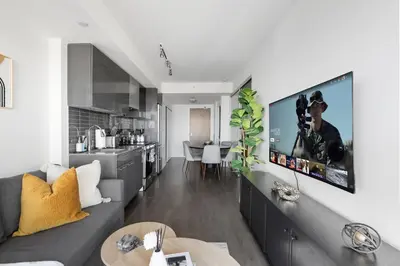 a living room with a couch and a kitchen at Bright 2BR Downtown Toronto Condo in Toronto