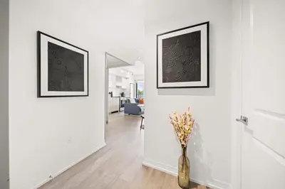 a hallway with two pictures on the wall and a vase at City Living Downtown Retreat Perfect Getaway in Toronto