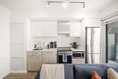 a kitchen with white appliances and a blue couch at City Living Downtown Retreat Perfect Getaway in Toronto