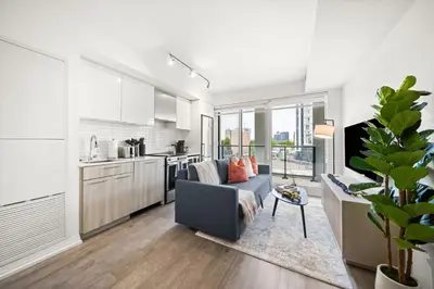 a living room with a couch and a kitchen at City Living Downtown Retreat Perfect Getaway in Toronto