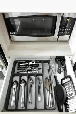 a drawer in a refrigerator with a stove and utensils at Luxe Downtown Studio Near Eaton Centre & Transit in Toronto