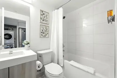 a white bathroom with a toilet and a sink at Luxe Downtown Studio Near Eaton Centre & Transit in Toronto
