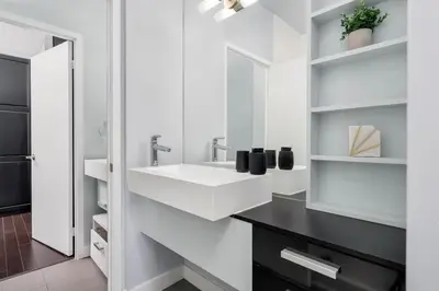 a white bathroom with a sink and a mirror at Glamorous City Escape King Bed & CN Tower Views in Toronto