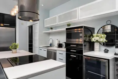 a kitchen with black appliances and white cabinets at Glamorous City Escape King Bed & CN Tower Views in Toronto