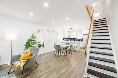 a living room with a staircase and a dining room at Stylish 3BR Urban Retreat near Christie Sleeps 6 in Toronto