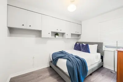 a bedroom with white cabinets and a bed with a blue blanket at Stylish 3BR Urban Retreat near Christie Sleeps 6 in Toronto