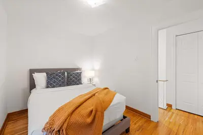 a white bedroom with a bed with a blanket on it at Stylish 3BR Urban Retreat near Christie Sleeps 6 in Toronto