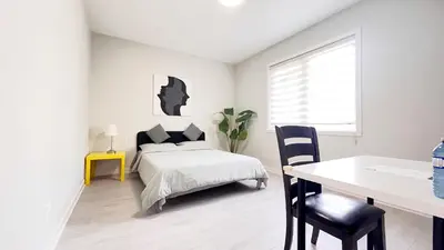 a bedroom with a bed and a desk and a table at Yonge Finch Subway Modern Suite with En Suite Bathroom in Toronto