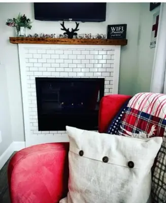 a living room with a red chair and a fireplace at The Klinck House in Collingwood