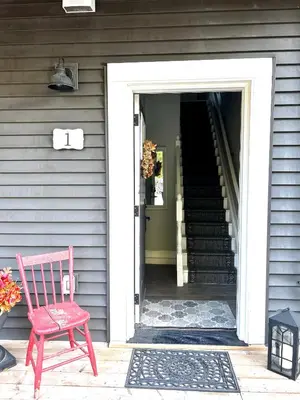a red chair sitting in front of a door at The Klinck House in Collingwood