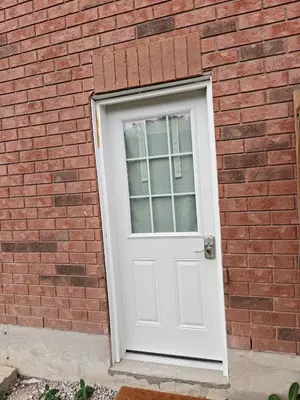 a white door on a red brick building at Pleasant stay Mississauga in Mississauga