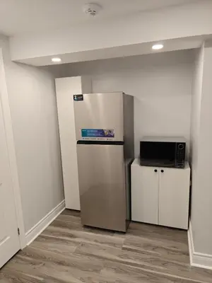 a room with a refrigerator and a microwave at Pleasant stay Mississauga in Mississauga