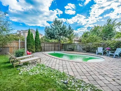 a backyard with a small swimming pool and a wooden fence at Pleasant stay Mississauga in Mississauga