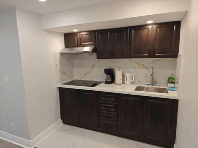 a kitchen with wooden cabinets and a sink at Pleasant stay Mississauga in Mississauga