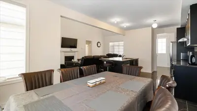 a dining room with a table and a living room at Modern Bay Vista Getaways in Carrying Place